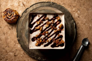 Decadent chocolate ice cream cake topped with fudge and nuts