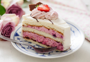 Strawberry ice cream cake with whipped cream and berry toppings.