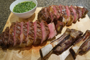 Cowboy steak on a grill with a bone-in presentation.