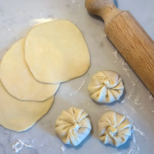 Rolling dumpling dough with flour and water.
