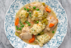 A bowl of Bisquick chicken dumplings with steam rising.